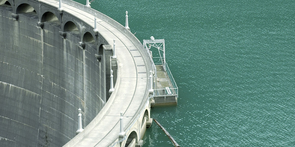 large dam next to greenish-blue water
