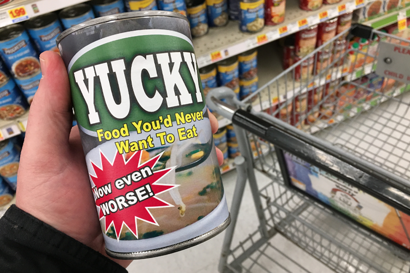 A man in a grocery store holding a can of food labeled "Yucky" representing food you wouldn't want to buy.
